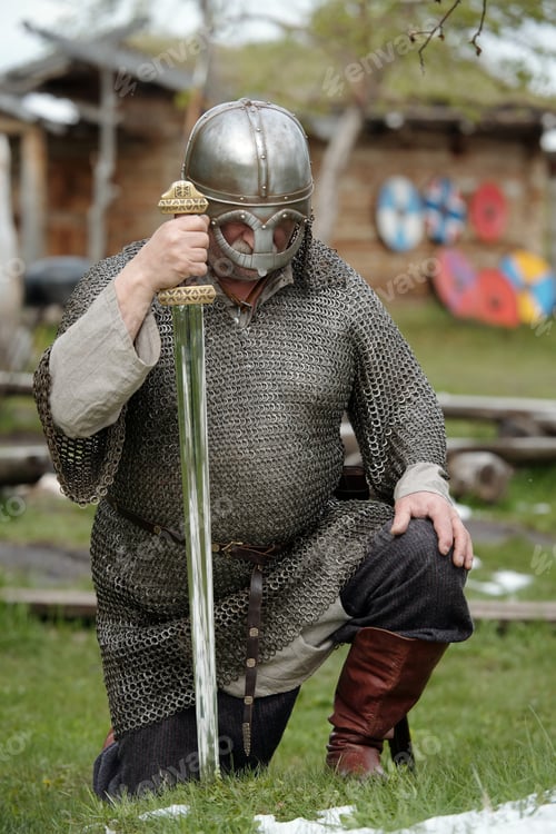 Preview: Kneeling Medieval Warrior Holding Sword in Battle Armor