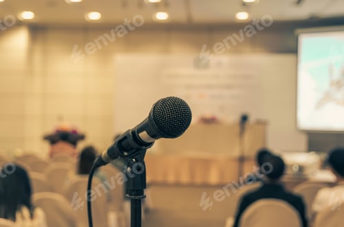 Preview: Microphone over the Abstract blurred photo of conference hall or seminar room background
