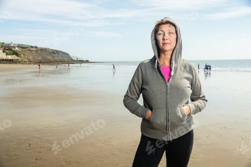 Preview: Woman on beach in hooded top, Folkestone, UK