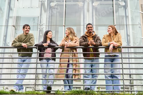 Visualização: Grupo de estudantes relaxando juntos em uma grade em frente a um edifício moderno