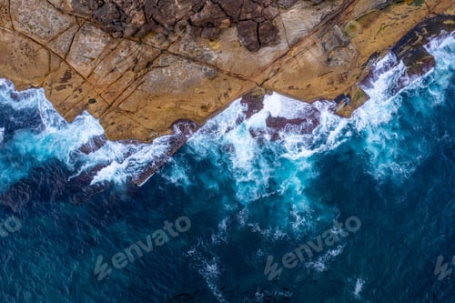 Preview: Top view of sea waves crashing on a rocky shore