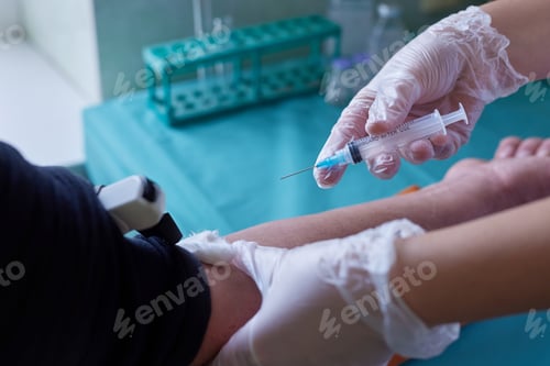 Preview: doctor gives an injection into a vein to a patient close-up
