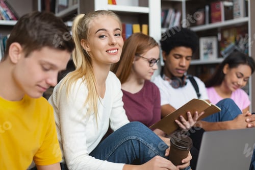 Preview: International group of students studying before exams at library