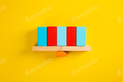 Preview: Balancing red and blue blocks on wooden seesaw over yellow background