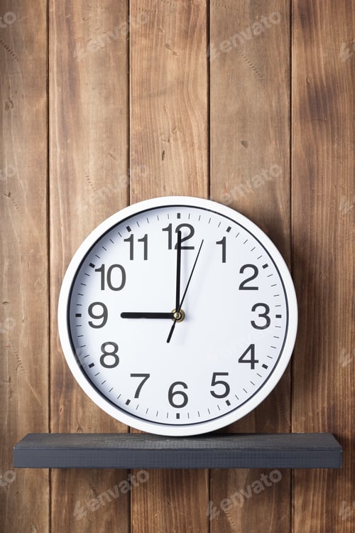 Preview: wall clock at shelf on wooden background