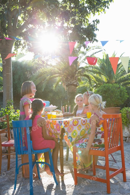 Preview: Girls sitting at table with birthday party food
