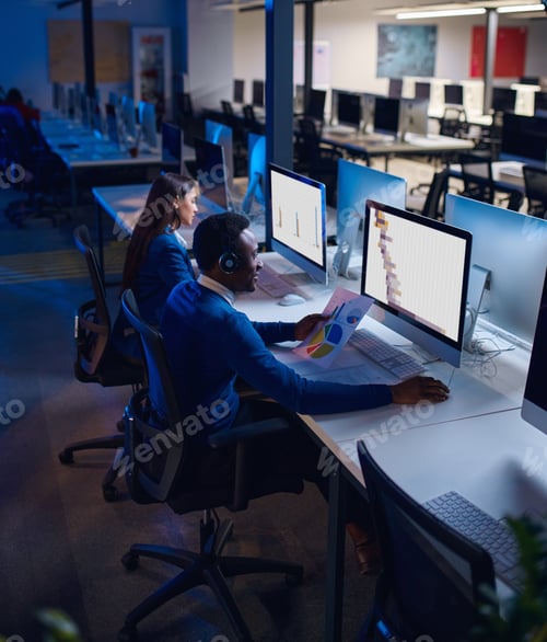 Preview: Two managers works in night office, back view