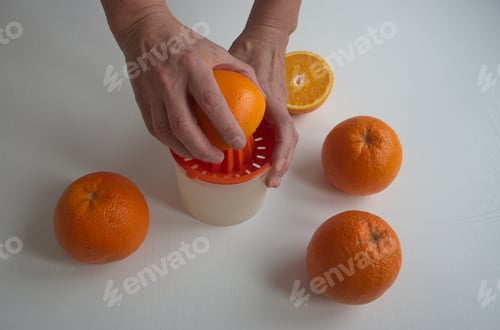 Preview: Cropped image of hands squeezing the orange