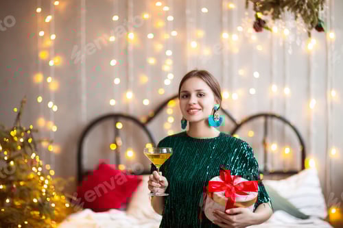 Visualização: Mulher alegre com champanhe e presente no dia de Natal