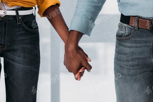 Preview: cropped image of african american couple holding hands at home