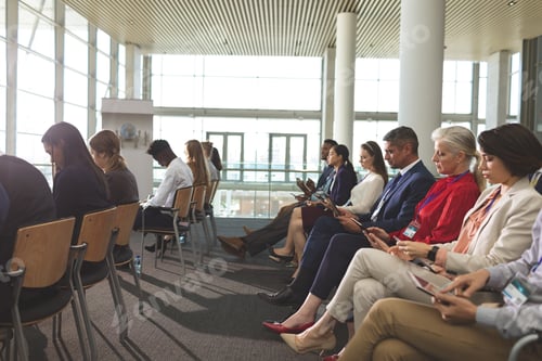 Preview: Side view of diverse business people using digital tablet during business seminar in office building