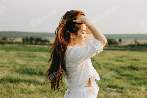 Preview: Portrait of beautiful carefree long hair asian girl in the white clothes on field at sunset