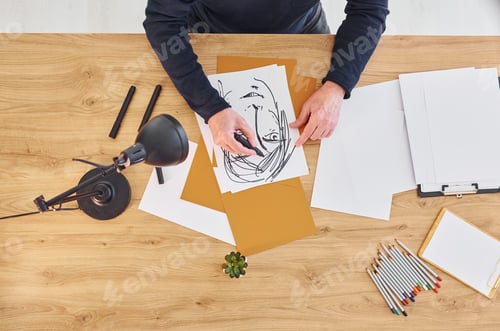 Preview: Top view of painter that working on the sketch of a man
