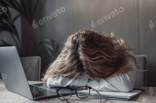Preview: Exhausted young Caucasian female employee sleep desk at office overwork preparing report