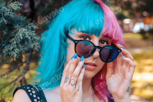 Preview: Cool girl with tattoos and colorful hair staring through her shades