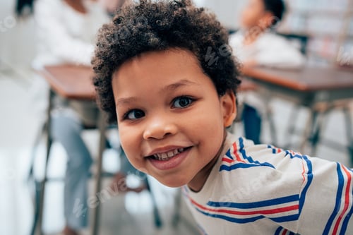 Preview: Portrait of young boy laughing in a classroom.