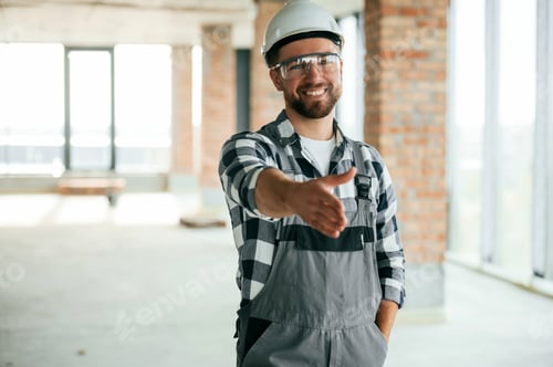 Preview: Giving the hand to shake, nice to meet you gesture.Construction worker in uniform in unfinished room