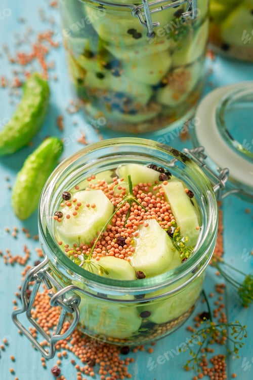 Preview: Homemade and tasty canned cucumber on blue table