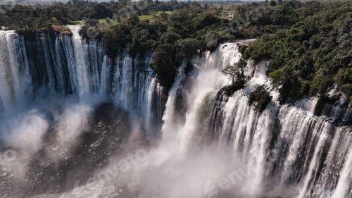 Preview: Kalandula Waterfall cascades in Angola surrounded by lush greenery during daylight