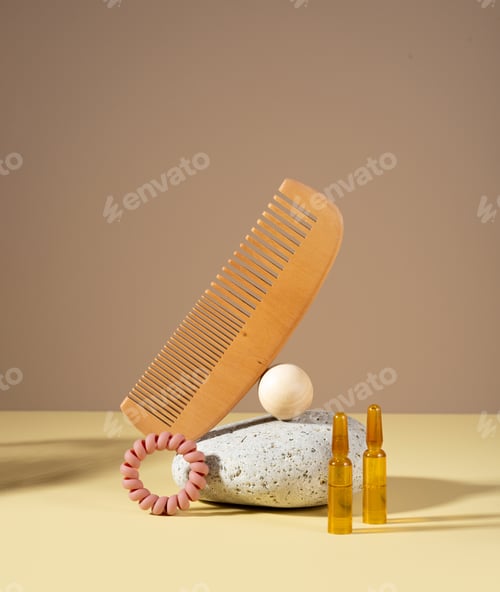 Preview: Cosmetic ampoules with serum for hair growth, restoration. Hair comb and stone on a light background