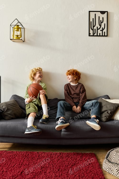 Preview: Joyful boys enjoying a fun basketball moment in their modern apartment