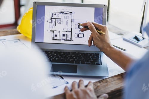 Preview: Architect and engineer discuss building blueprint design on laptop and construction project planning