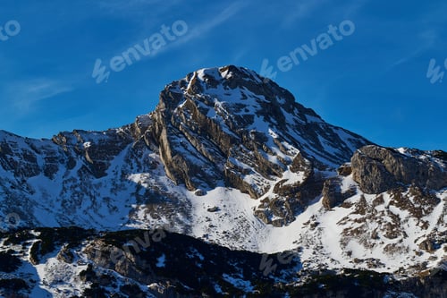 Preview: Stunning snow-capped mountain peak under a clear blue sky