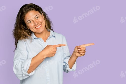Preview: Cheerful woman pointing to the side and smiling