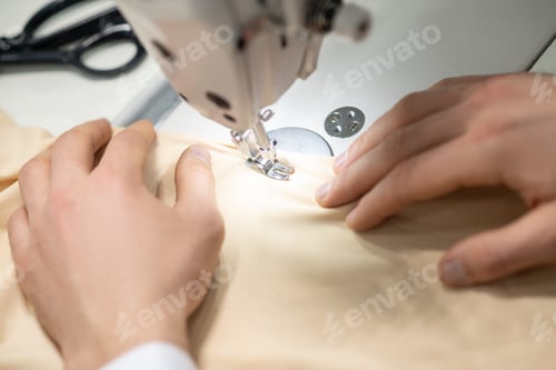Preview: Hands of male tailor on sewing machine