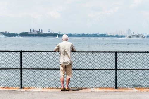 Preview: Old man watching at New York Harbor on promenade