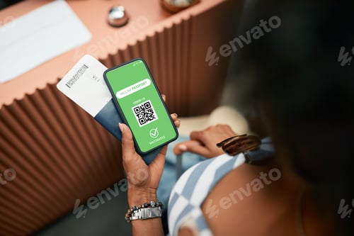 Preview: Close-up of vaccinated woman with COVID-19 certificate on smart phone during checking in at hotel.