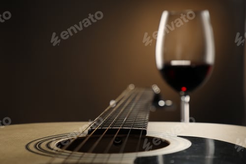 Preview: Acoustic guitar and glass of red wine on black background, closeup. Space for text