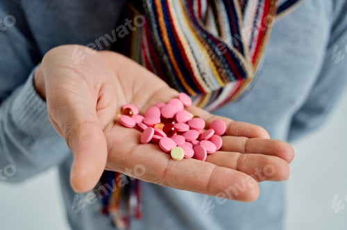 Preview: sick man in a sweater with pills in hand health problems light background