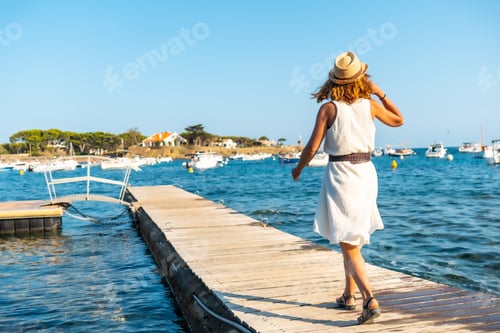 Preview: A young woman in a dress in Cadaques walking along the sea, Costa Brava of Catalonia
