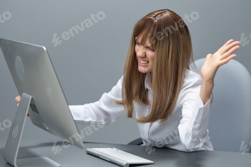 Preview: Angry evil pretty blonde businesswoman worker screaming to desktop Raging after computer software