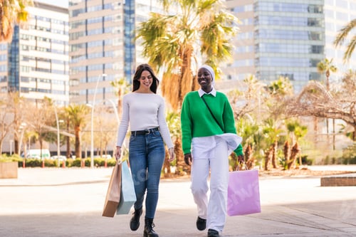 Preview: two female friends walking in a shopping area