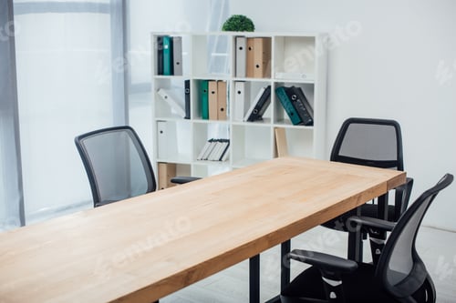 Preview: Wooden table and chairs near rack with paper folders in office