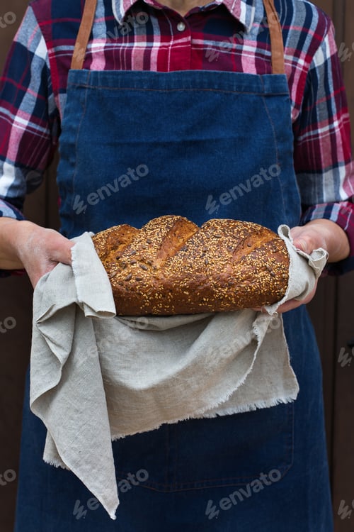 Preview: Fresh loaf of homemade rye bread in woman hands
