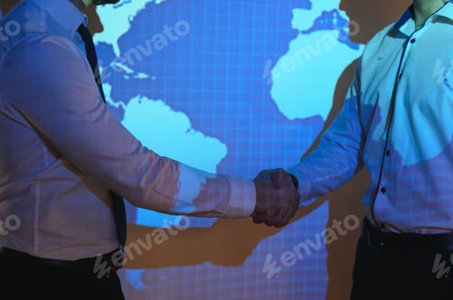 Preview: Handshake with map of the world in background. two businessmen on the background of the world map