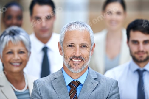 Preview: Portrait of a smiling businessman surrounded by a group of his colleagues