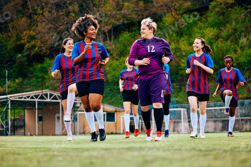 Preview: Happy female soccer players running during a practice at the stadium.