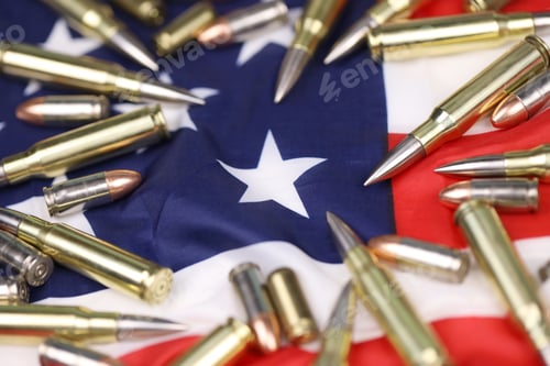 Preview: Many yellow 9mm and 5.56mm bullets and cartridges on United States flag