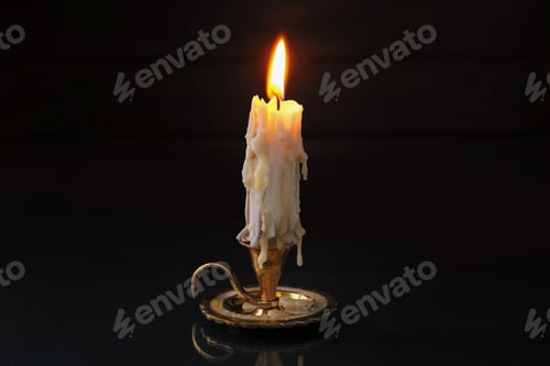 Preview: Burning candle in candlestick on mirror surface in darkness