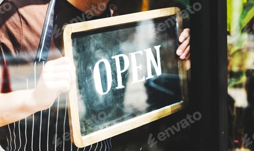 Preview: Man putting on shop open sign