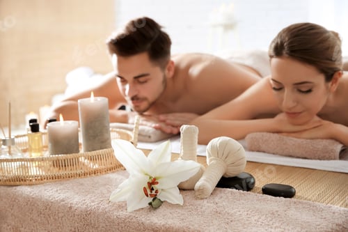 Preview: Young couple with spa essentials in wellness center