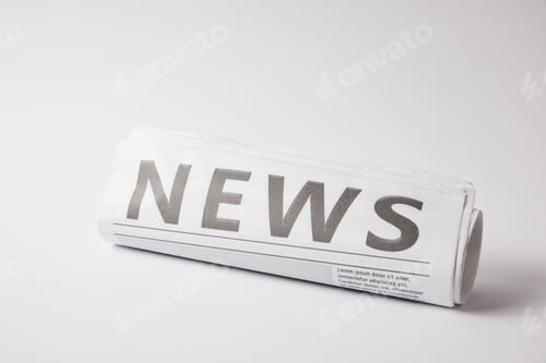Preview: rolled newspaper lying on white background