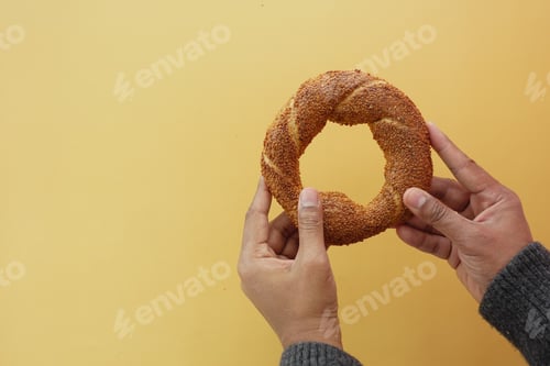 Preview: hand holding a turkish Bagel Simit