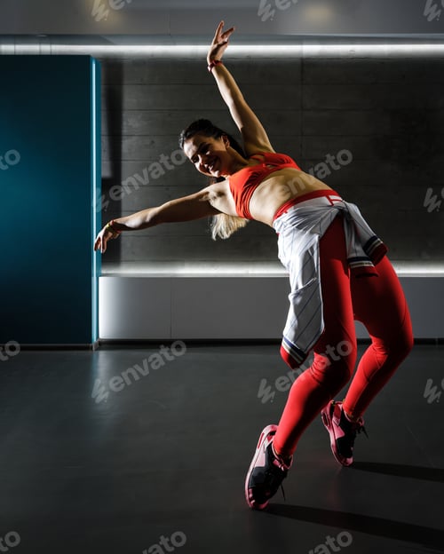 Preview: Young active fit woman dancing on the floor in the gym
