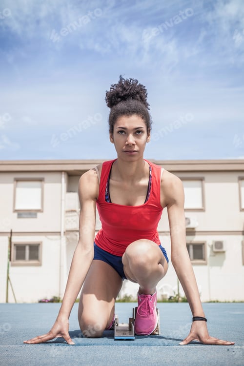 Preview: Young female sprinter on her marks on running track
