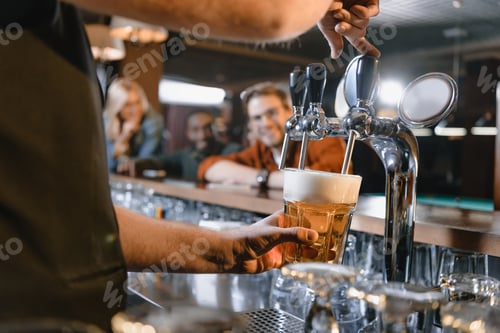 Preview: cropped image of barman pouring beer in glass at bar